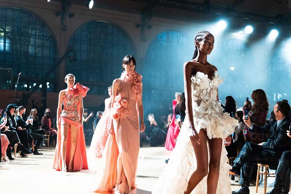 Runway show atmosphere at Paris Fashion Week with a full audience