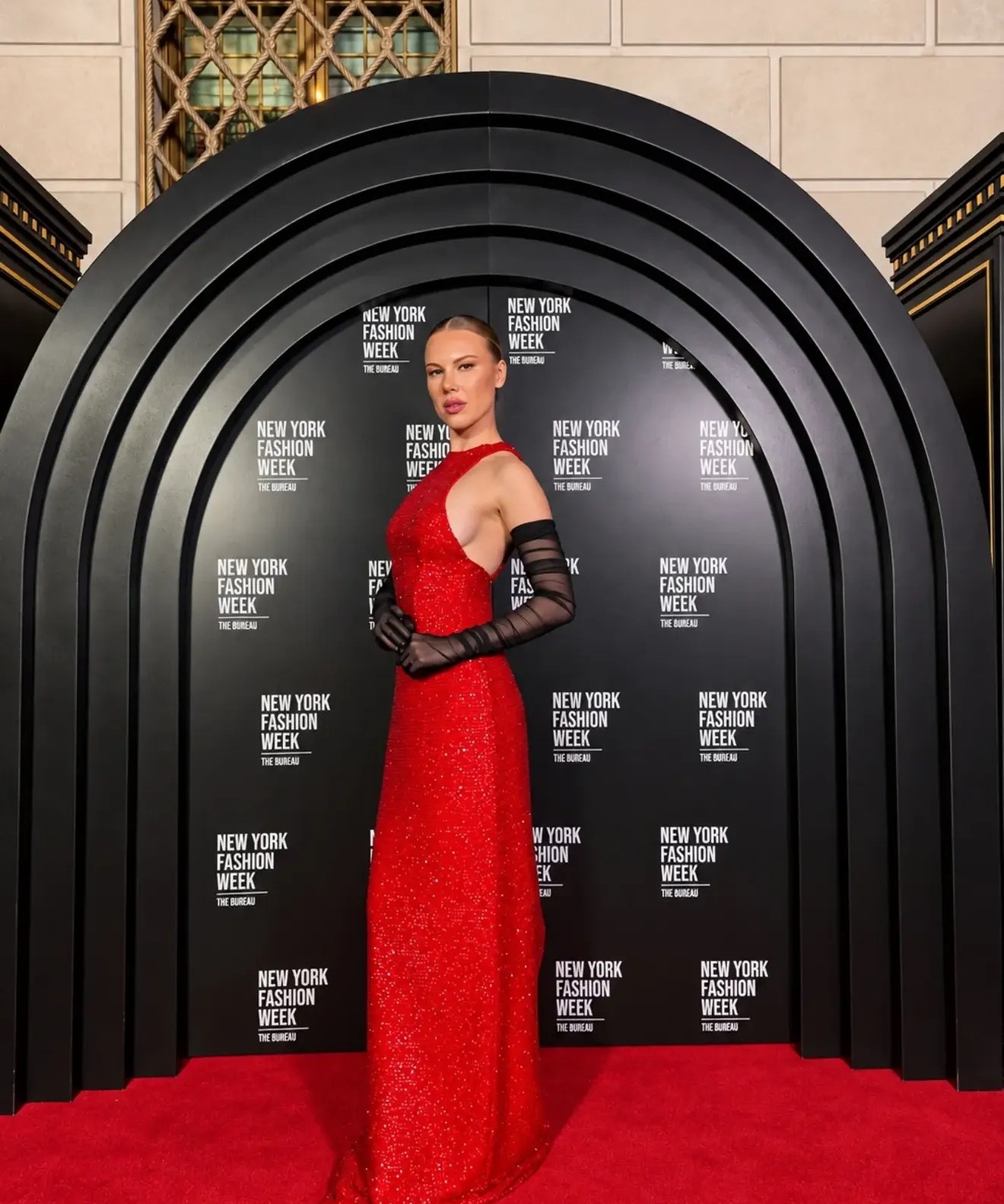 Model in a red sequin gown on the New York Fashion Week red carpet by The Bureau